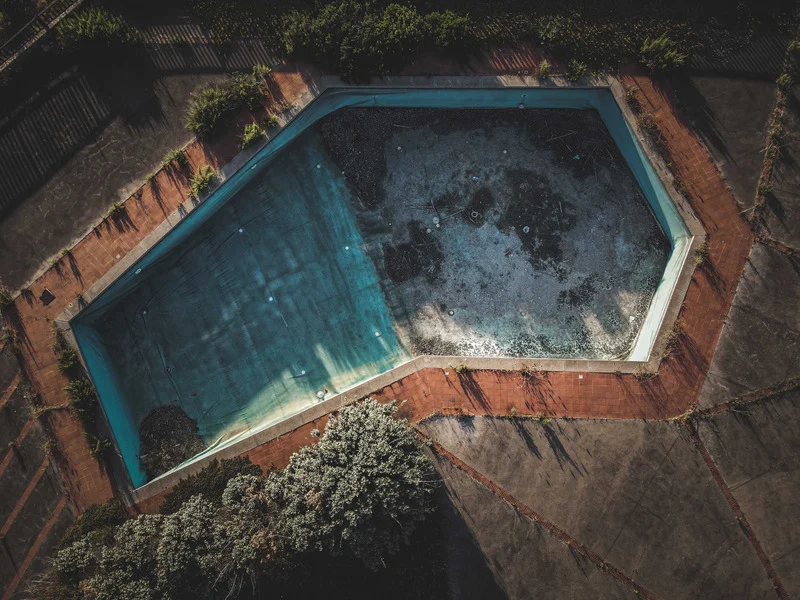 Pool Construction Cost Ottawa – custom inground pool with slide and patio seating.