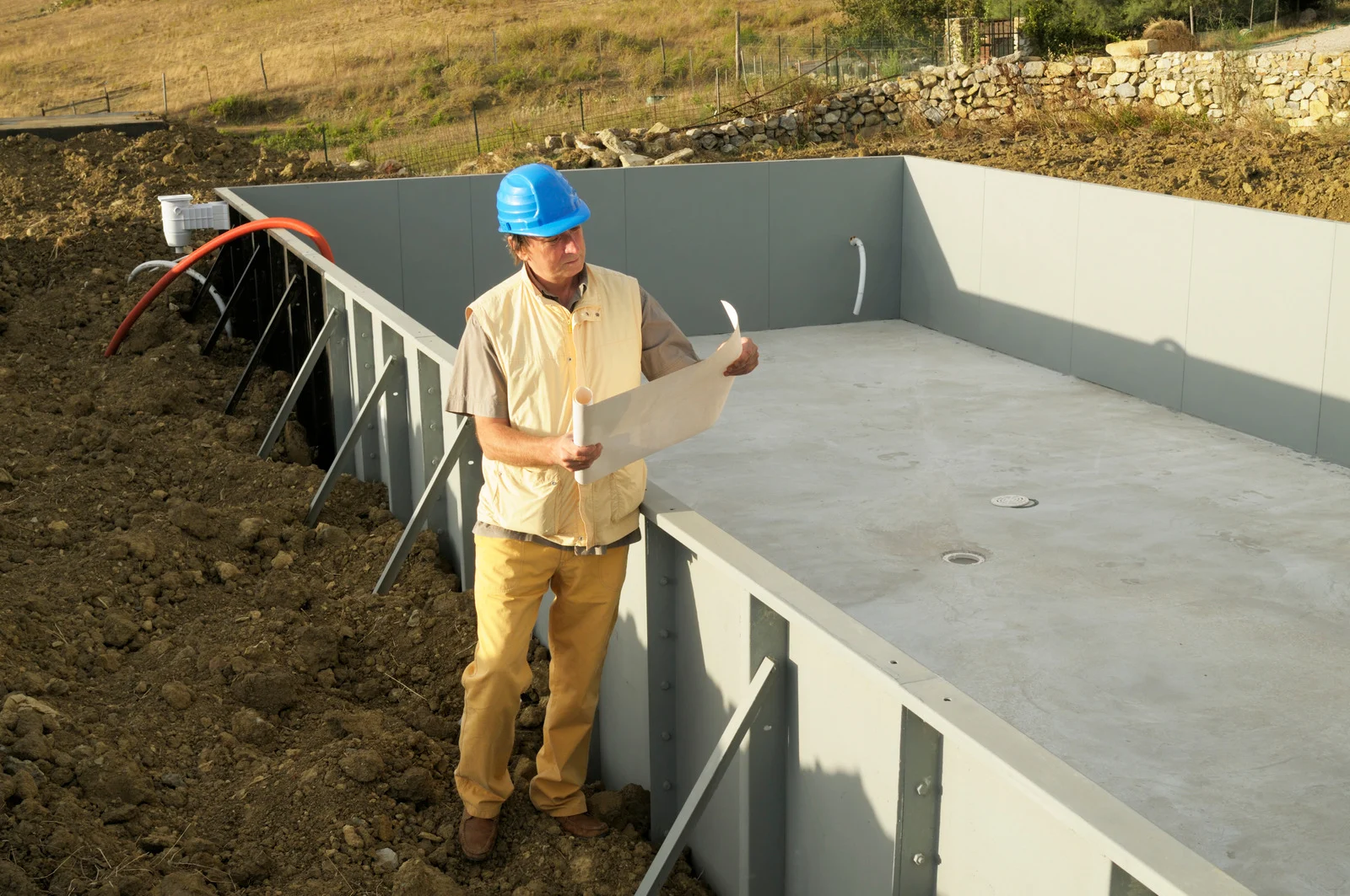 Swimming Pool Construction Ottawa – contractor reviewing plans beside the pool structure.